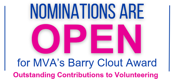 Whitney leaning against a railing on a downtown street