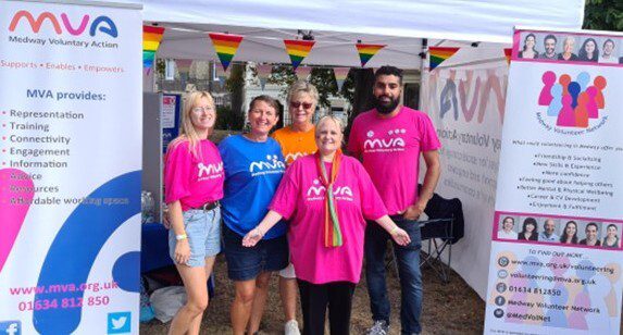 Whitney leaning against a railing on a downtown street