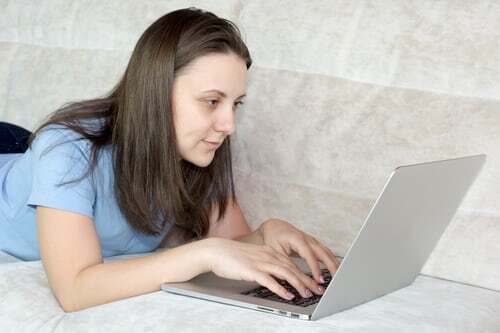 Whitney leaning against a railing on a downtown street