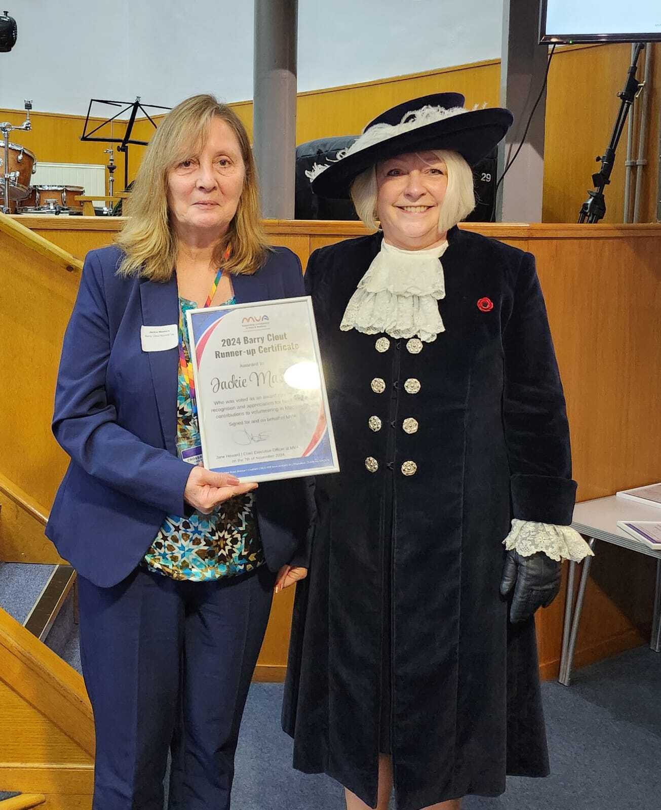 Whitney leaning against a railing on a downtown street