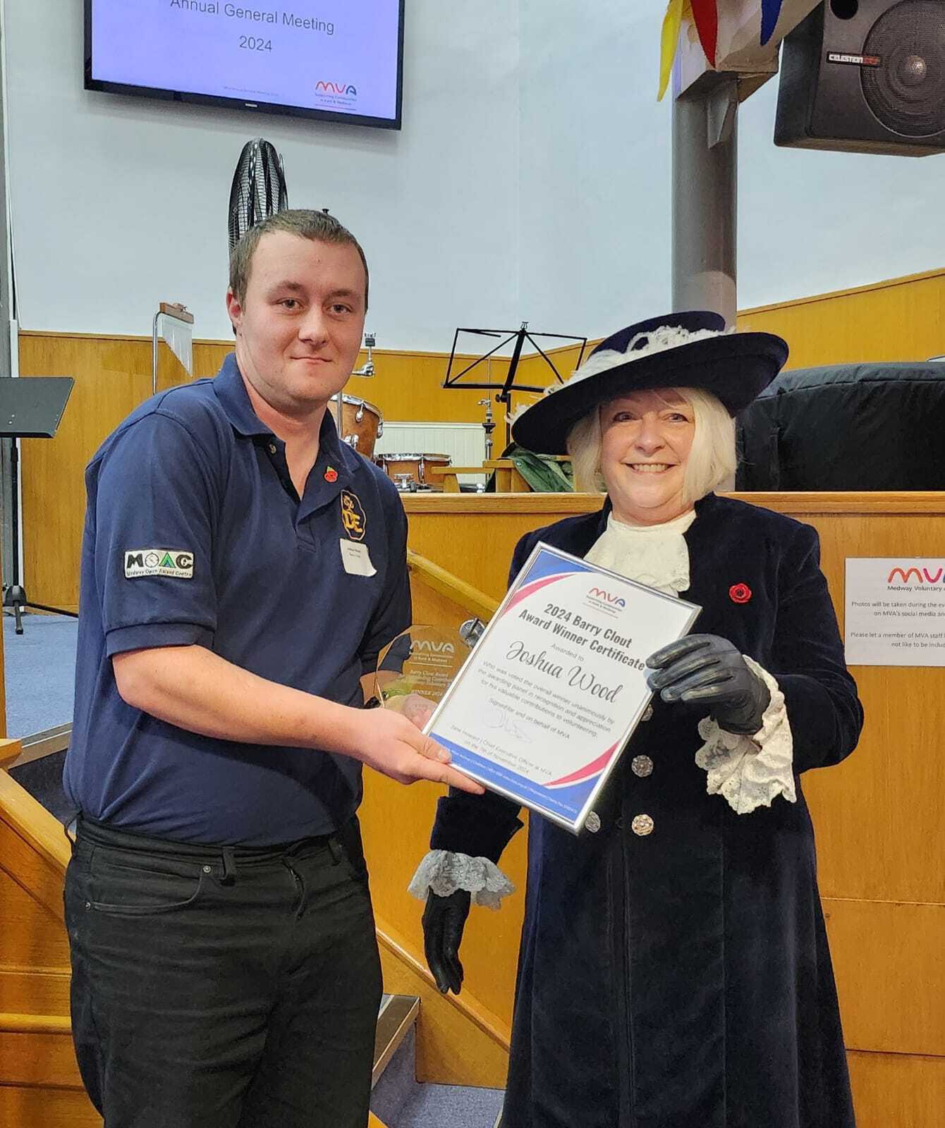 Whitney leaning against a railing on a downtown street