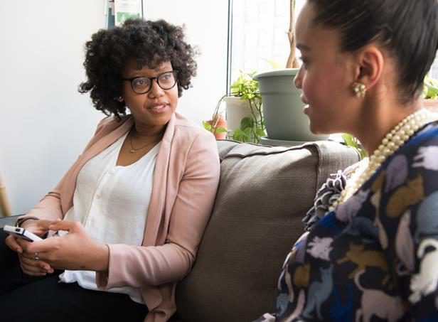 Whitney leaning against a railing on a downtown street